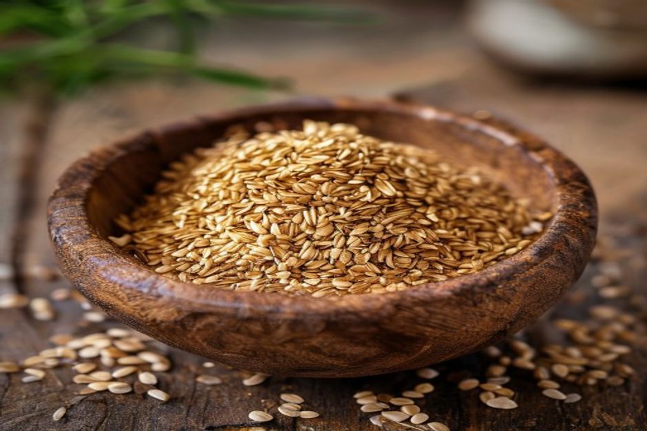 tiny golden amaranth seeds in a wooden bowl